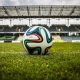 A football on the pitch in a stadium